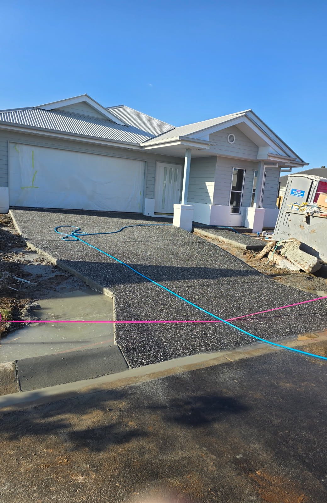 Exposed aggregate concrete driveway freshly poured at a new build home